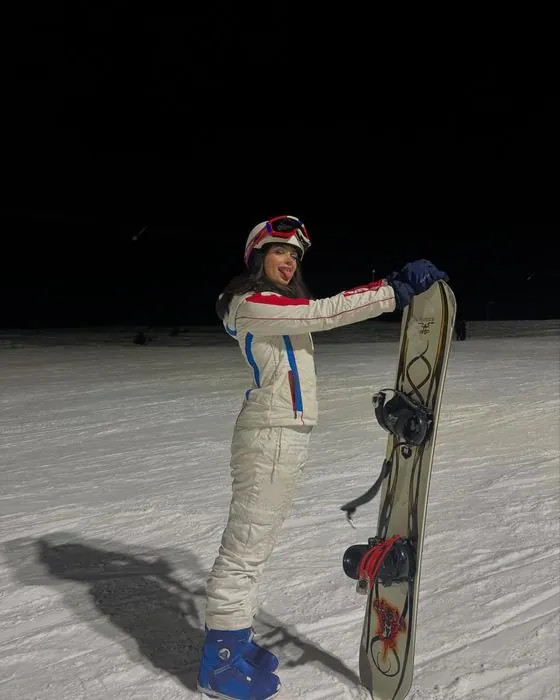 Gizem Özdemir gece kayağında, elinde snowboard